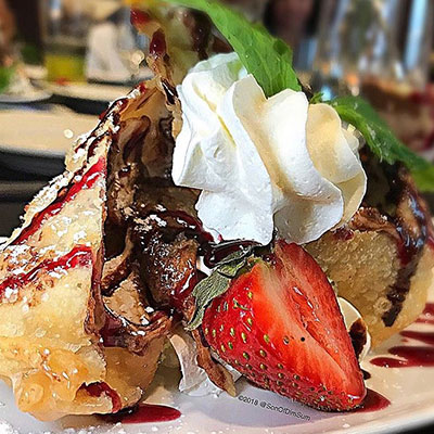 fried banana wonton with whipped cream and strawberries