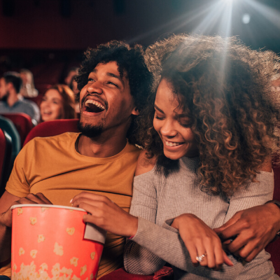 man and woman enjoying popcorn at the movies